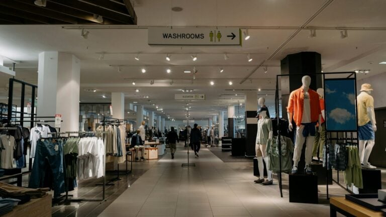 The clothing floor of a department store with racks of garments and dressed mannequins
