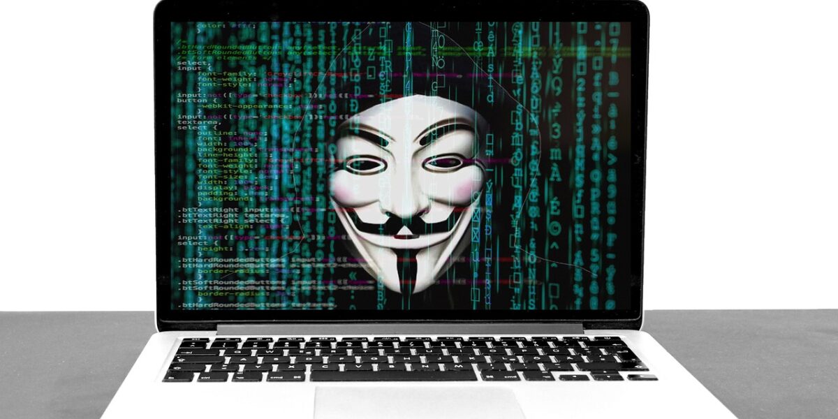 A laptop screen showing a mask over columns of green code