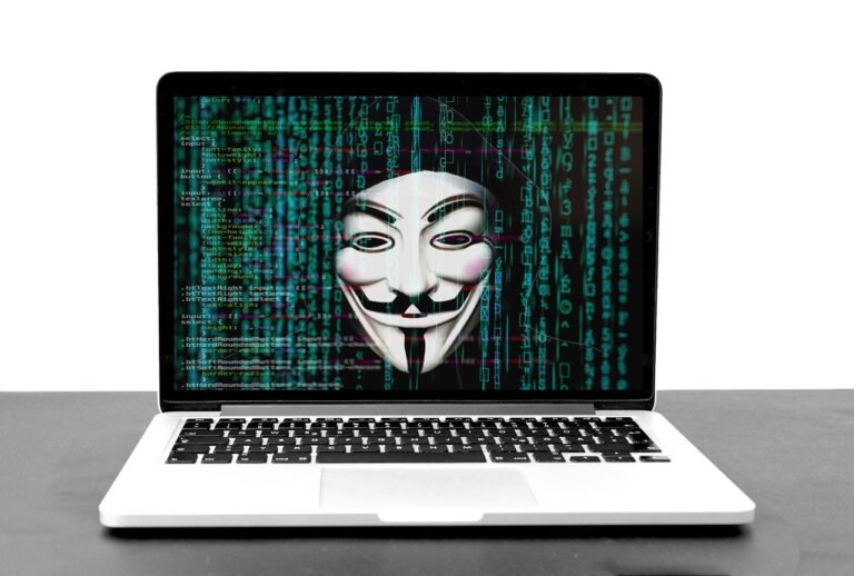 A laptop screen showing a mask over columns of green code
