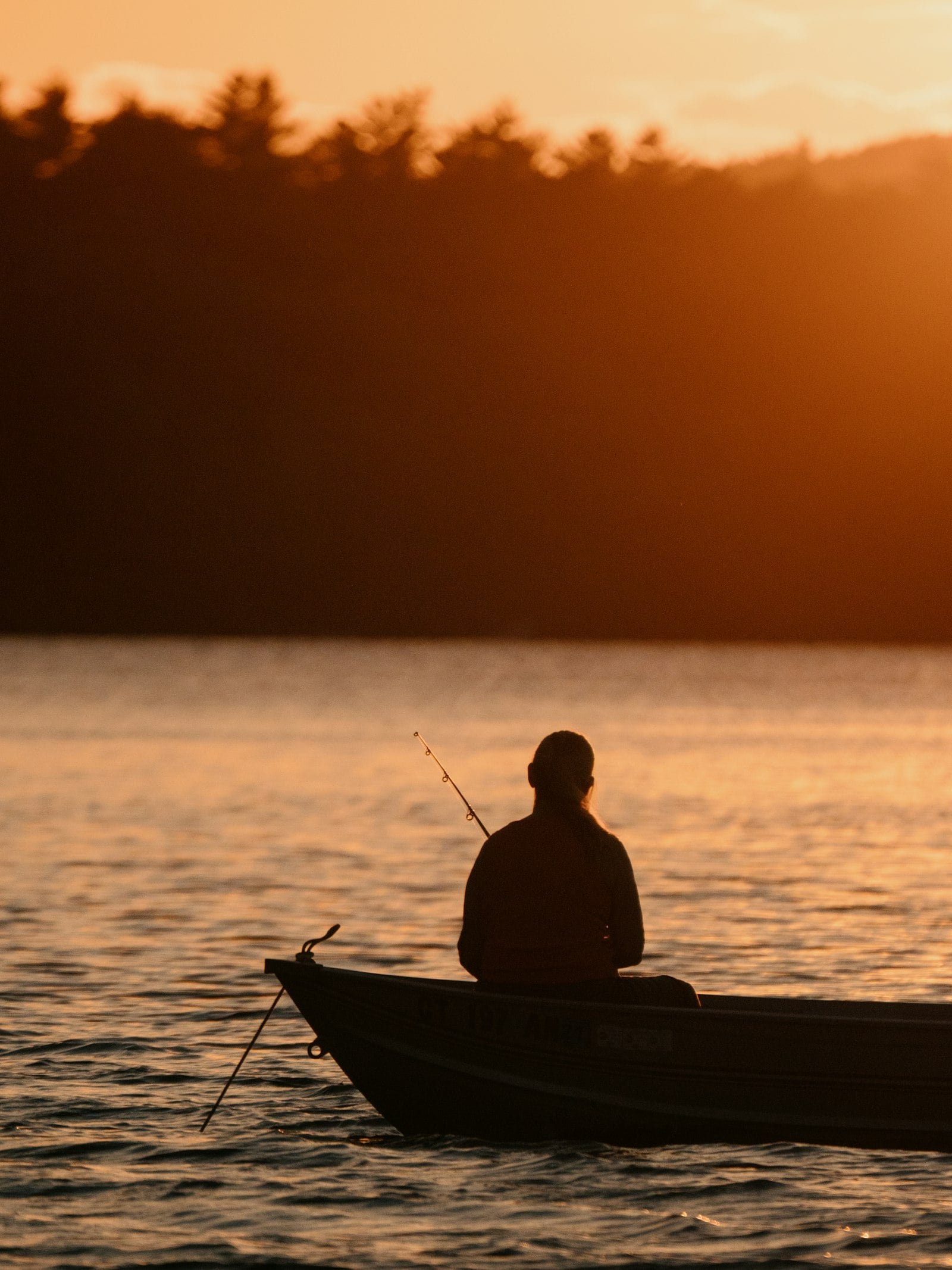 Angler in a small boat at sunset (photo: Mark Olsen / Unsplash)