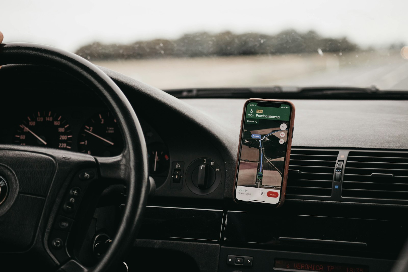 Phone with a map app mounted on a car dashboard (photo: Isaac Mehegan / Unsplash)