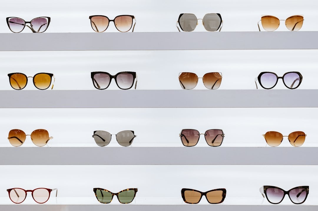 Rows of assorted sunglasses displayed on white retail shelves