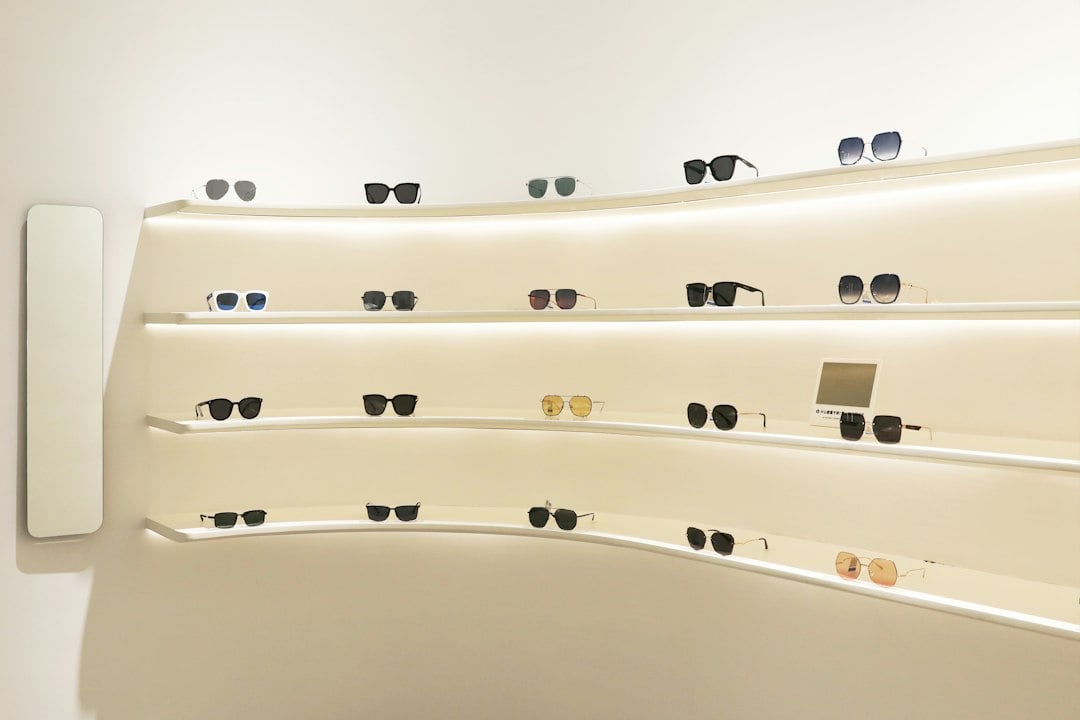 Sunglasses displayed on curved cream shelves in a minimal store interior