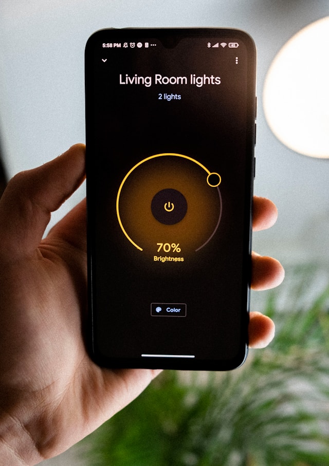 A hand holding a phone displaying a circular brightness dial set to 70 percent
